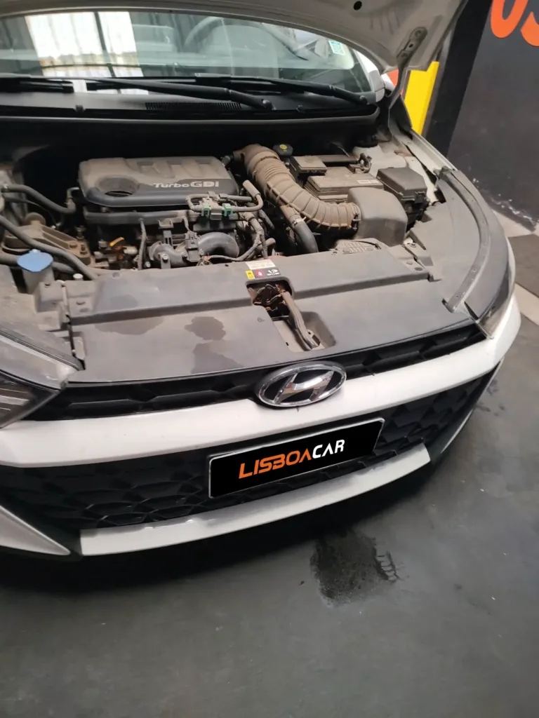 Hyundai HB20 2024 branco com capô aberto na Lisboa Car Center em Porto Alegre — troca do compressor de ar condicionado e recarga de gás