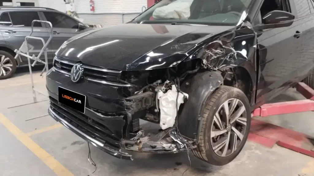 VW Virtus Highline 2025 preto com colisão frontal lateral — dano no para-lama, farol e para-choque esquerdo registrado no local do acidente antes do reboque para a Lisboa Car Service Porto Alegre