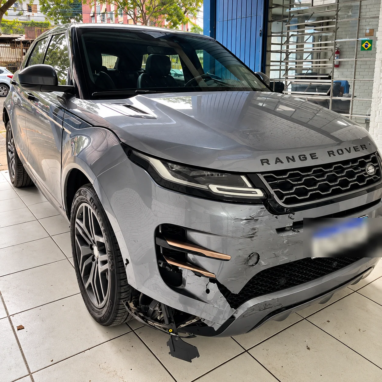 Range Rover Evoque 2020 cinza com a frente danificada após colisão com motocicleta, na Lisboa Car Service em Porto Alegre